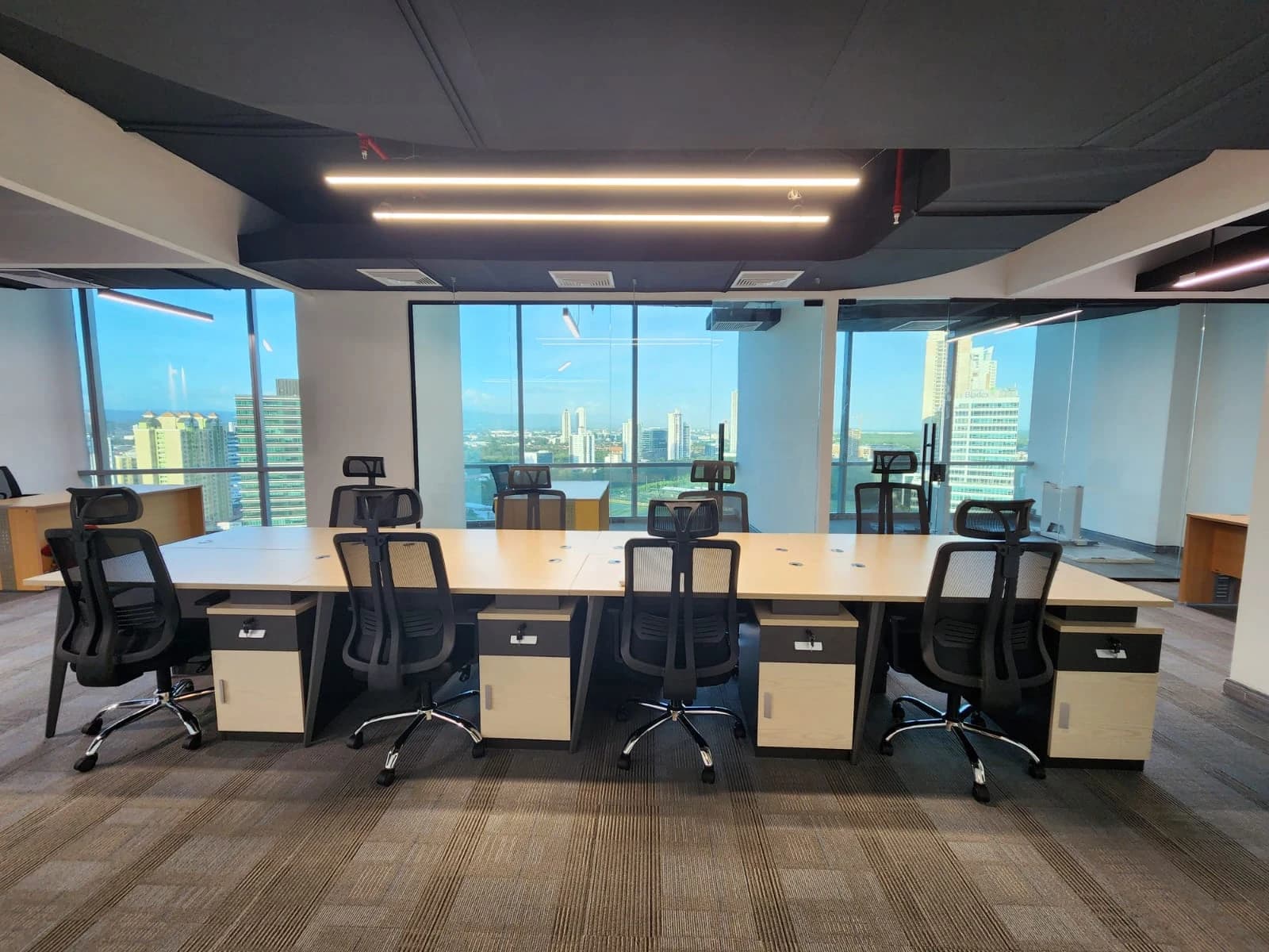 A fitted office interior with shared desks and enclosed rooms.
